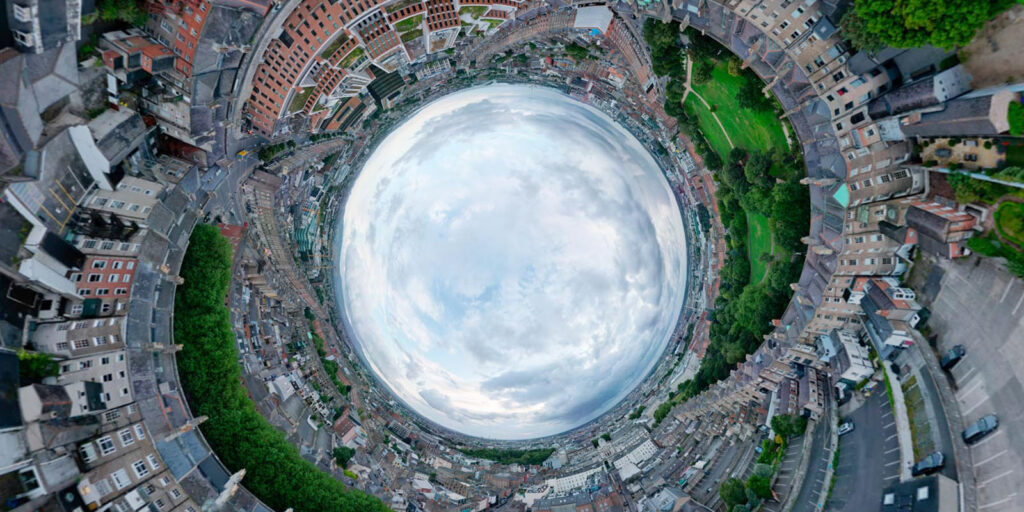Aerial tiny planet view of a curving urban landscape.