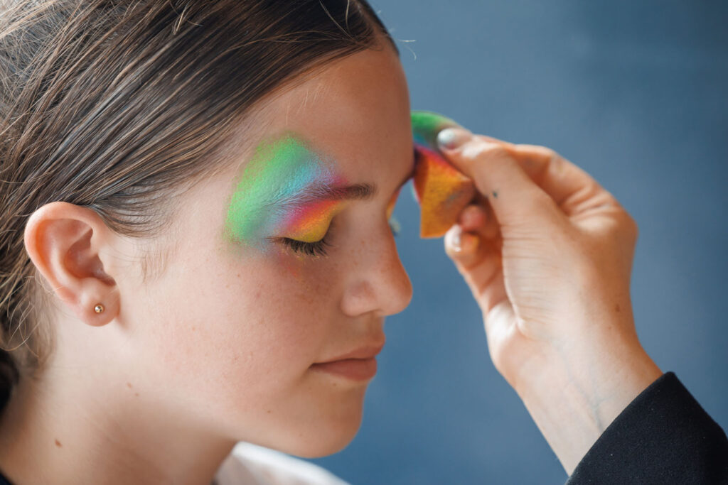 Applying vibrant rainbow eye makeup