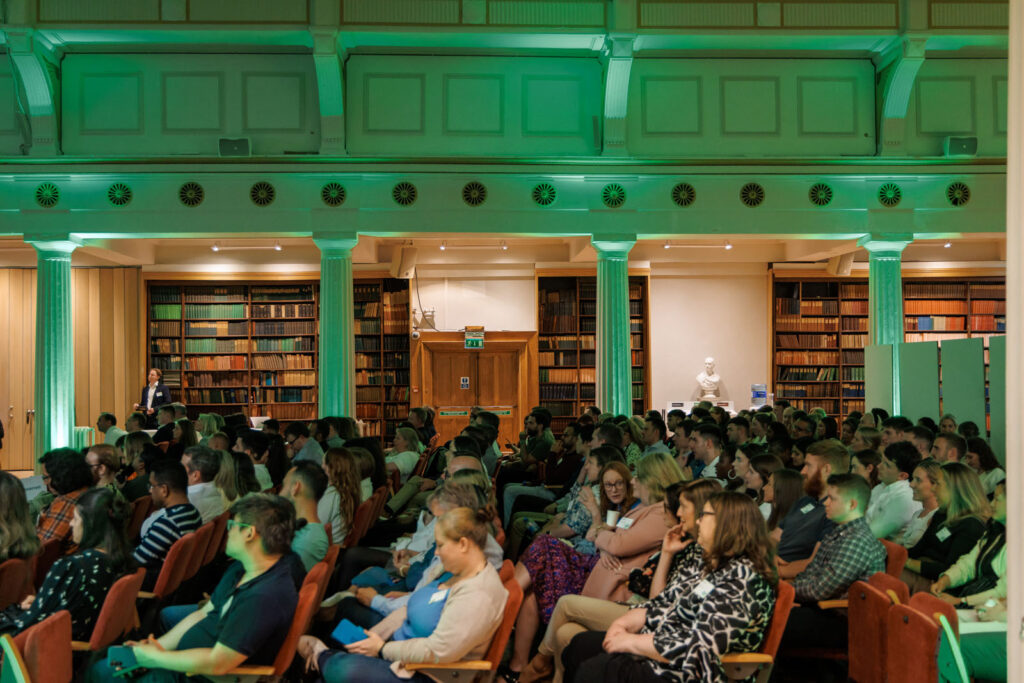 Audience listens to speaker in a lecture hall.