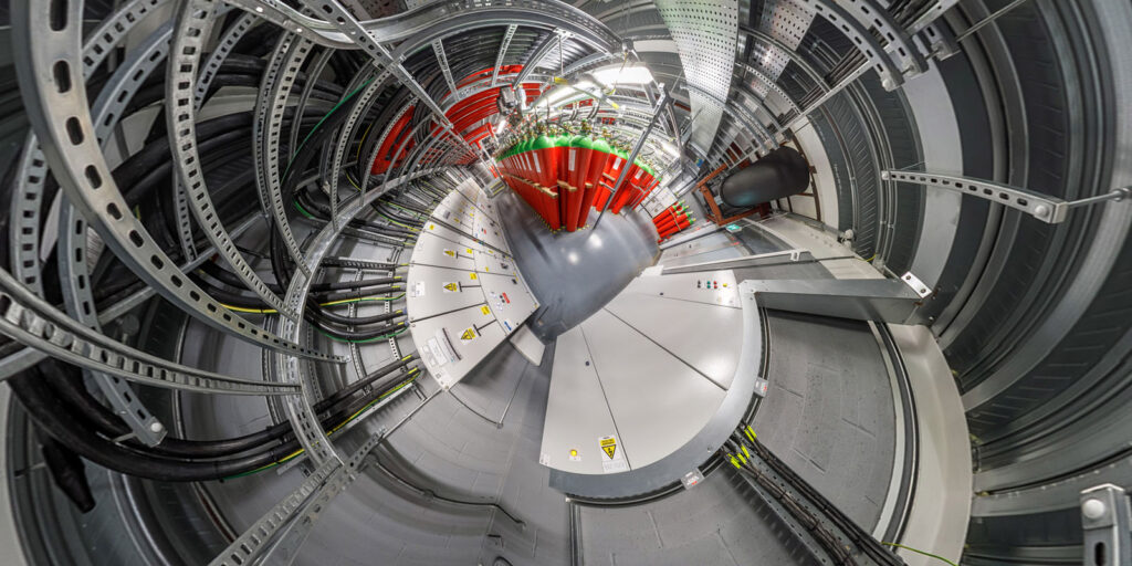 Circular industrial room with extensive cabling and fire suppression systems.