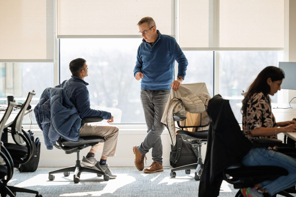 Colleagues conversing in a bright office space.