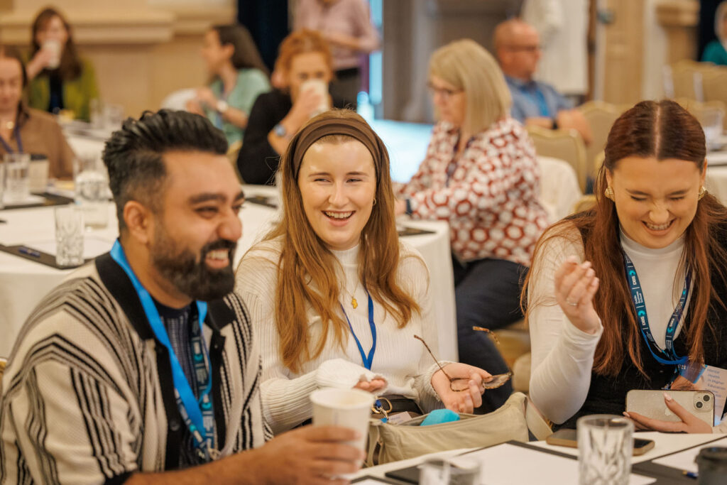 Conference attendees laughing and enjoying the event.