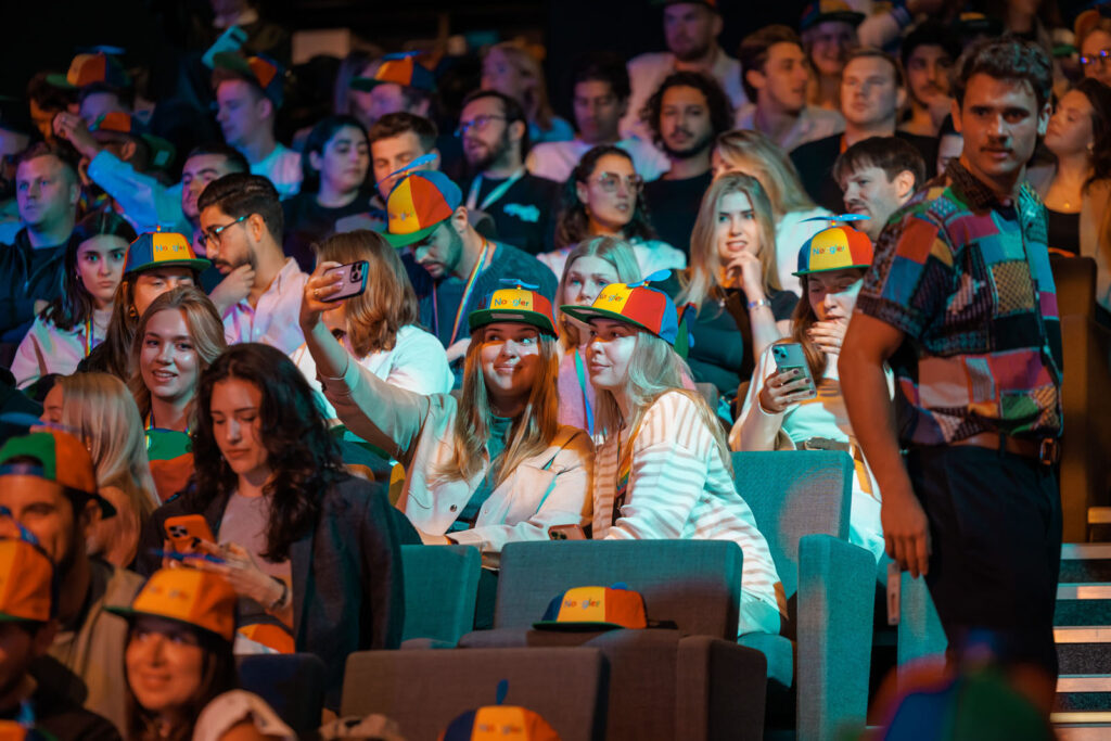 Crowd of young people wearing "Noogler" propeller hats.