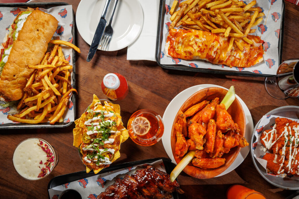 Delicious spread of American comfort food: wings, ribs, nachos, fries.