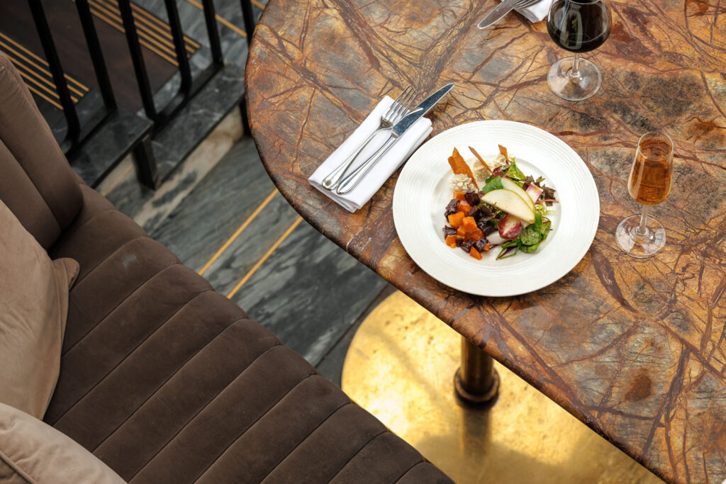 Elegant dining: salad, wine, and champagne on marble.