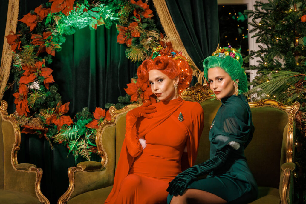Elegant women in red and green, festive holiday setting.