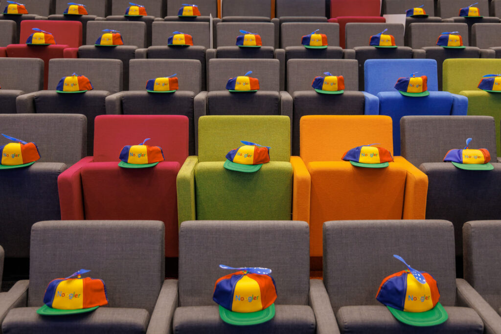 Empty chairs with "Noogler" propeller hats.