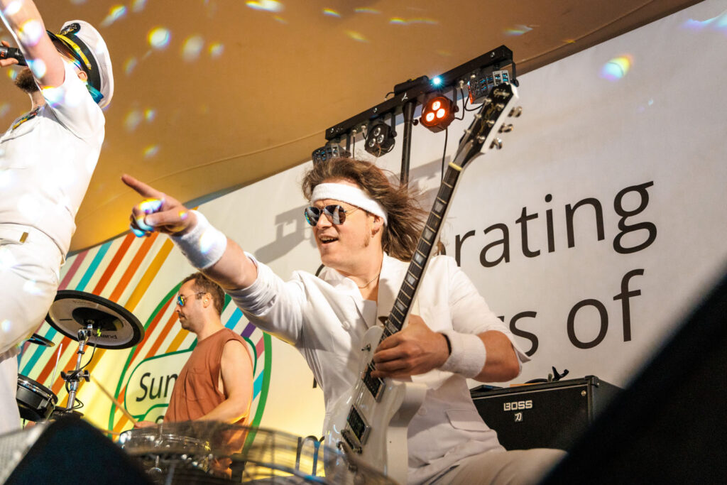 Energetic band performance with guitarist and singer on stage.