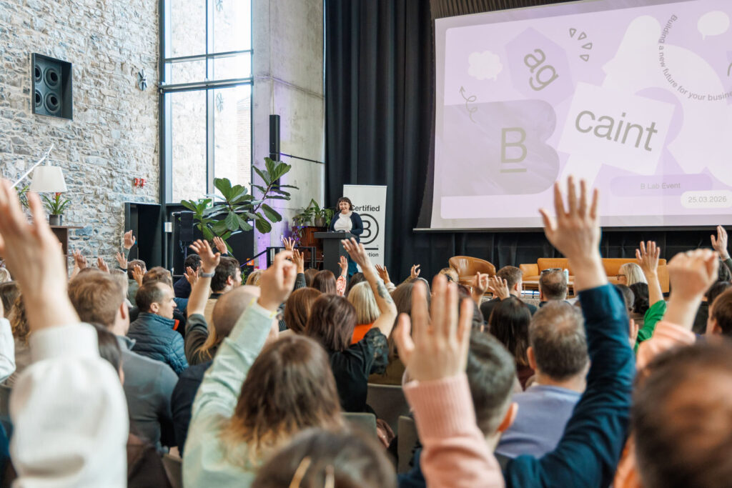 Engaged audience raises hands during a presentation.