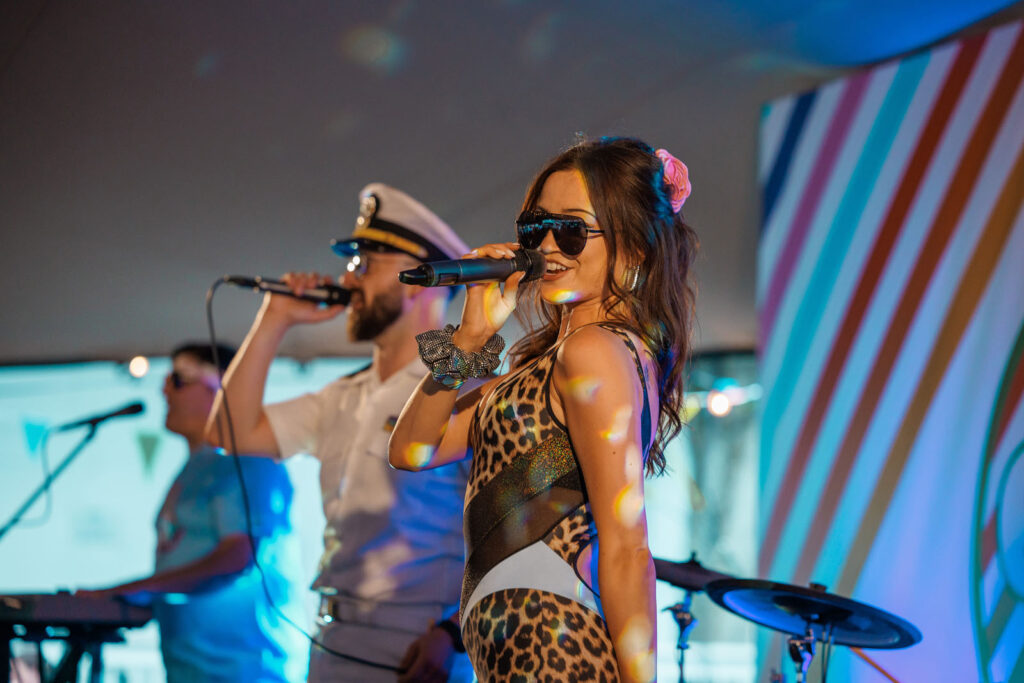 Female singer performs on stage with band.