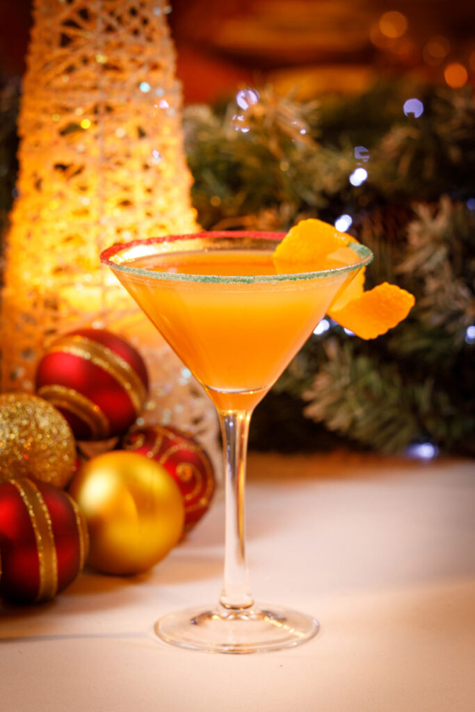 Festive orange cocktail with Christmas decorations.