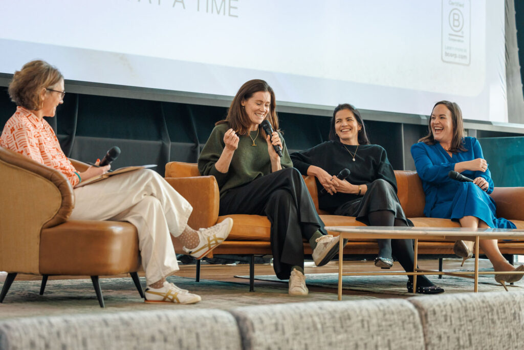 Four women laughing during a lively panel discussion.