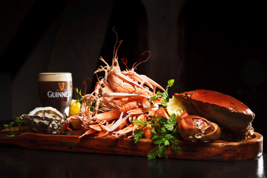 Fresh seafood platter with prawns, crab, oyster, and Guinness.