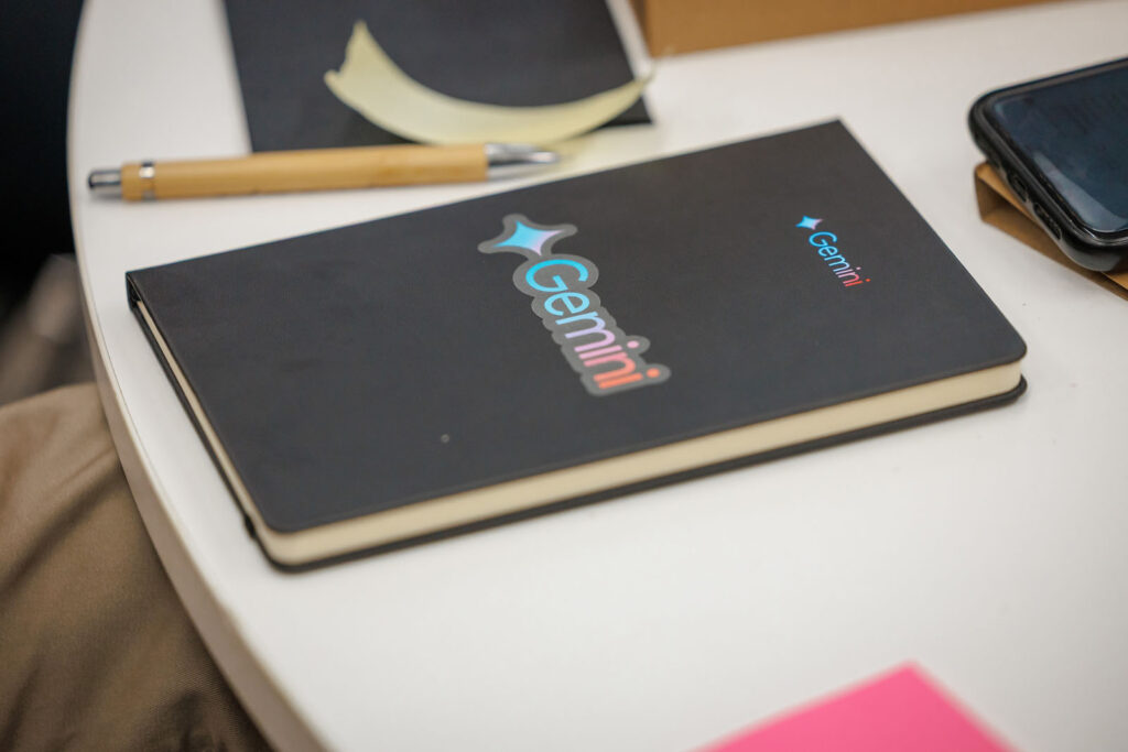 Gemini notebook, pen, and phone on a white table.