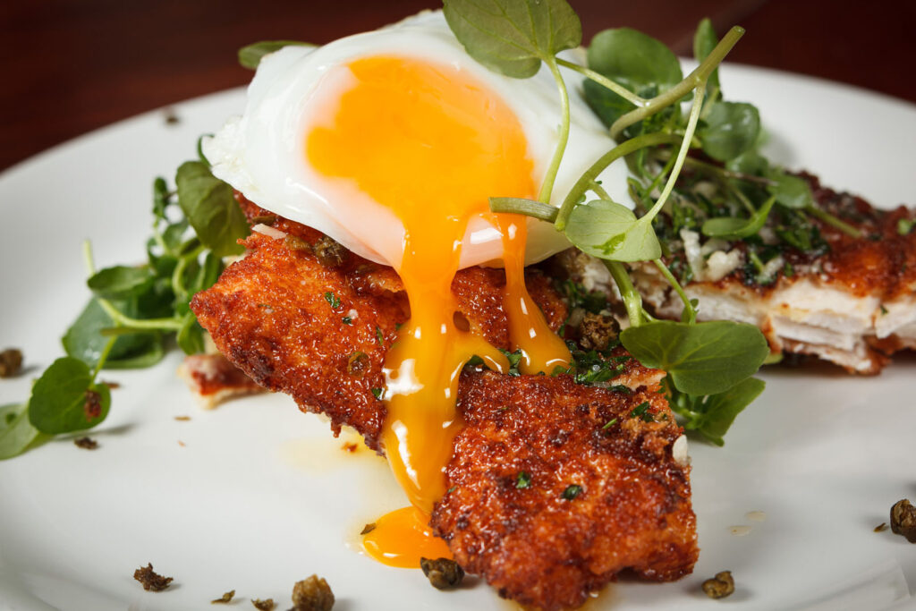Golden fried food with a runny egg and fresh greens.