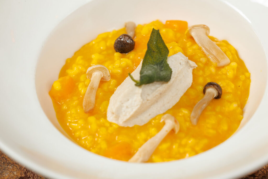 Gourmet pumpkin risotto with mushrooms, truffle, and sage.