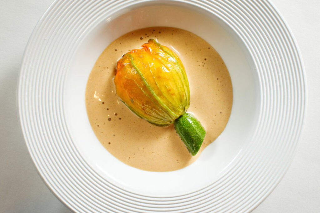 Gourmet stuffed zucchini flower in creamy sauce.