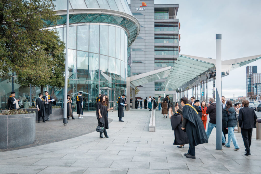 Graduates celebrating outside a modern building.