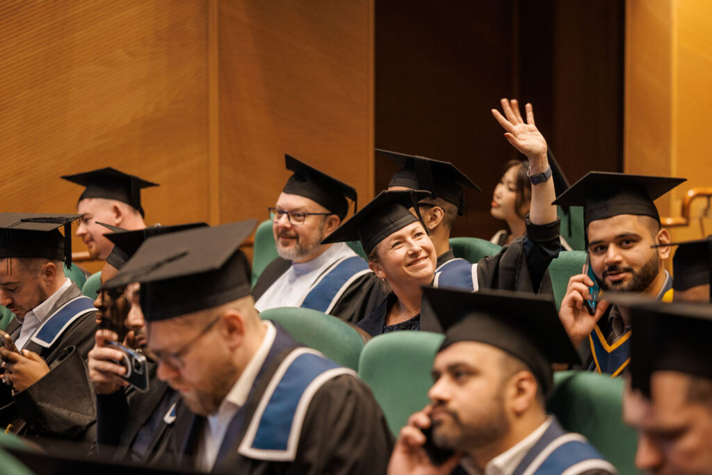 Graduates in caps and gowns attending a ceremony.