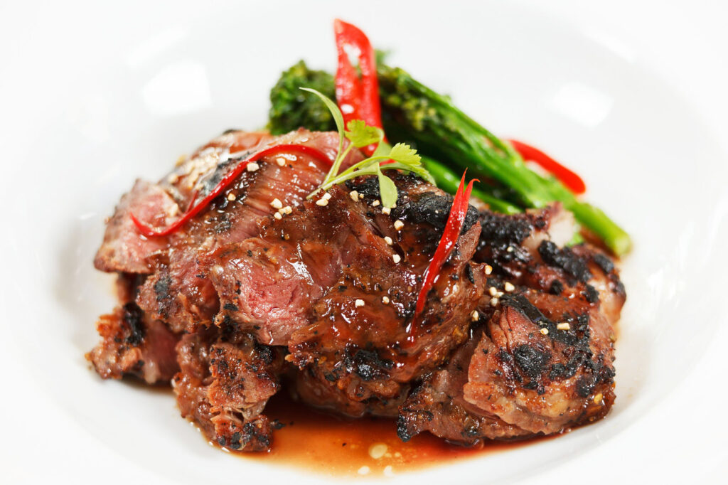 Grilled steak with chili, asparagus, and sesame seeds.