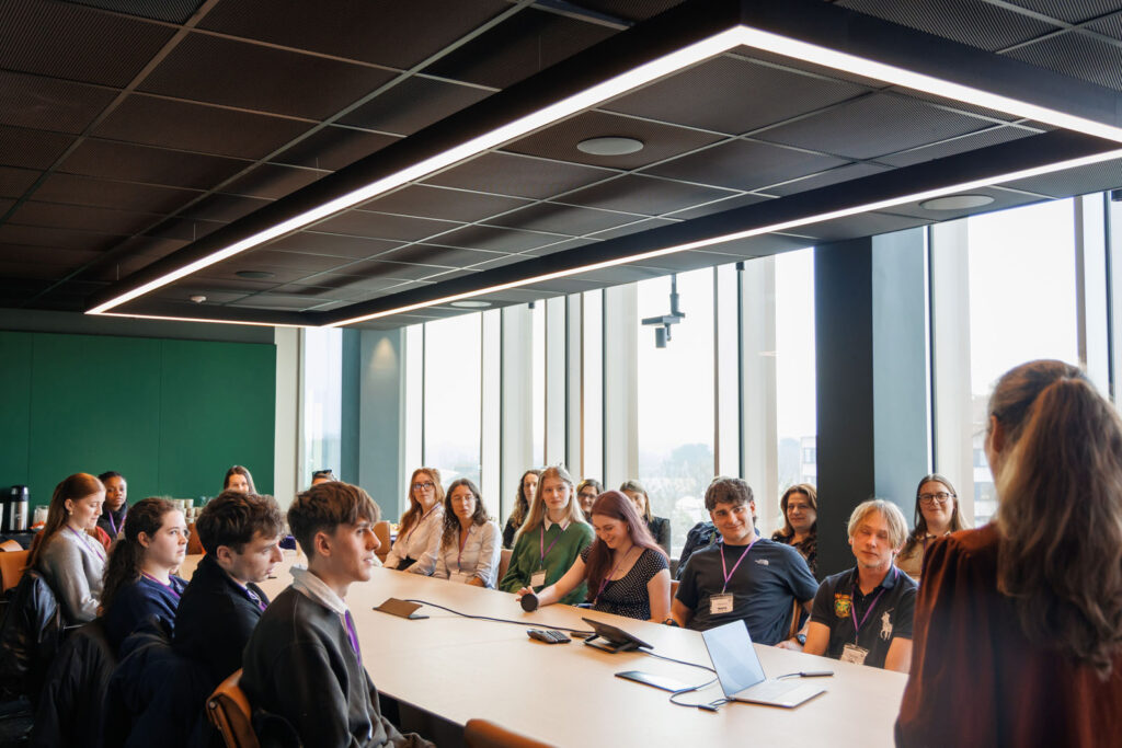 Group of young people listening to a speaker.