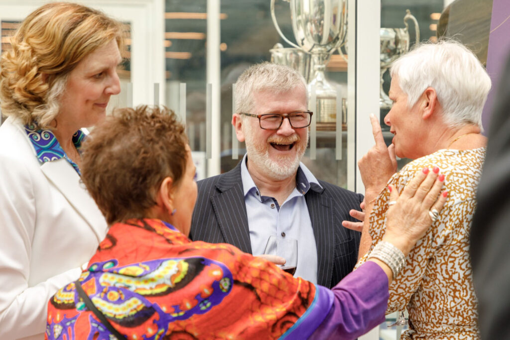 Guests laughing and socializing at an event.