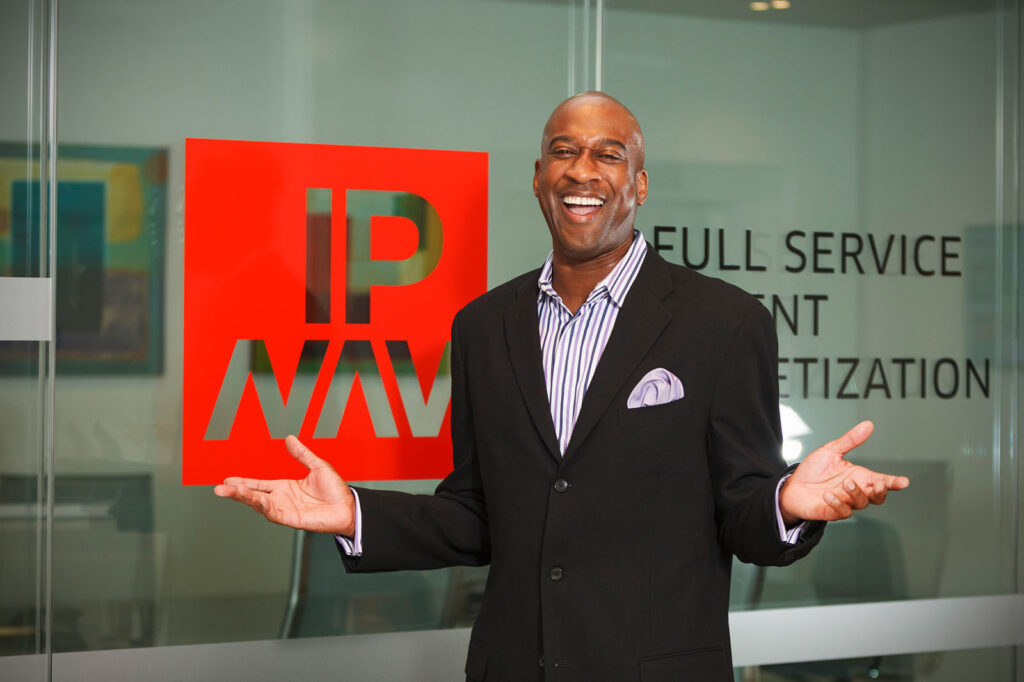 Happy businessman in suit in front of company logo.