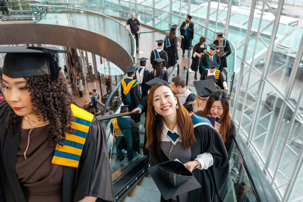Happy graduates on escalators.