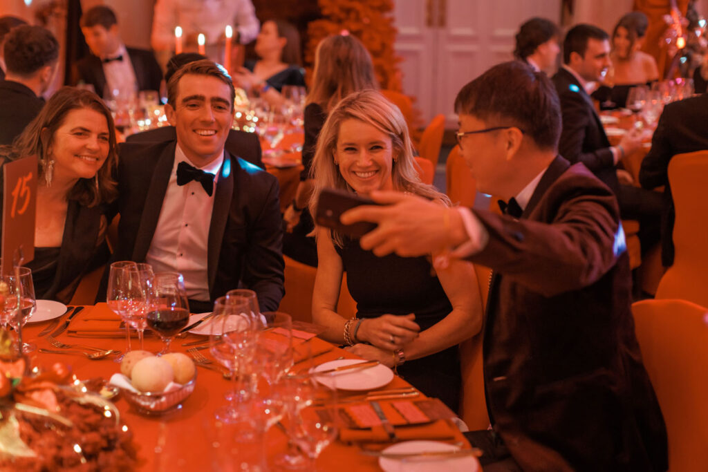 Happy guests taking a photo at a formal dinner.