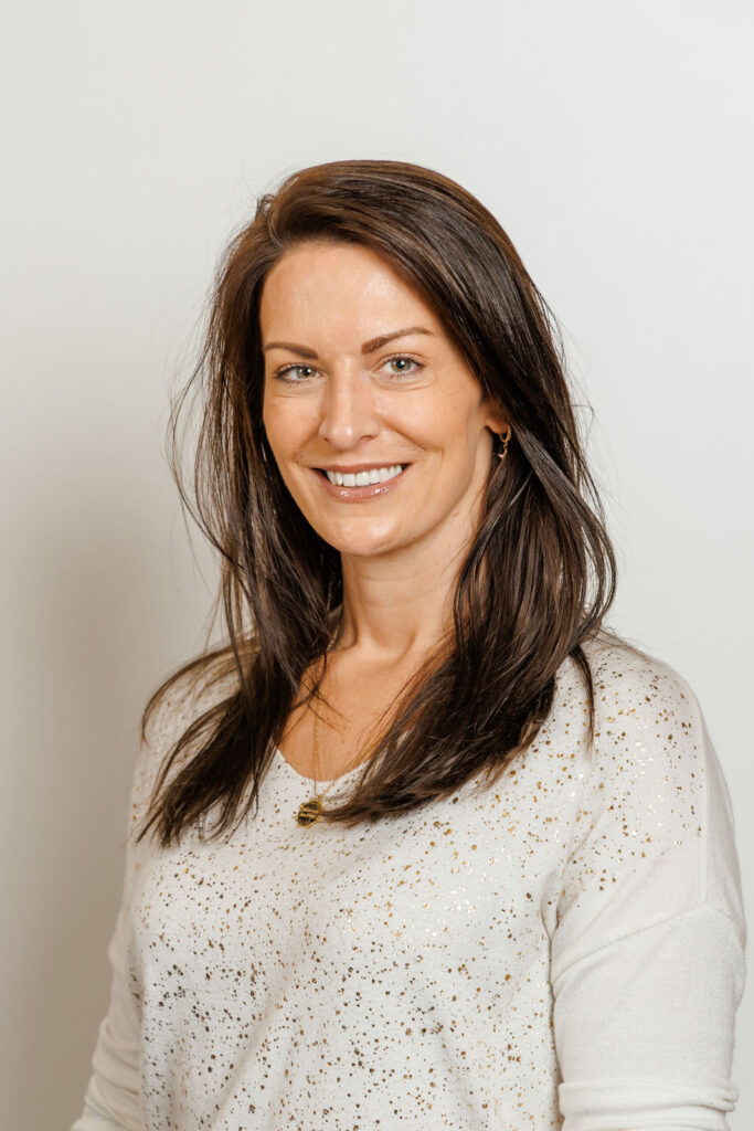 Happy woman in speckled white sweater.