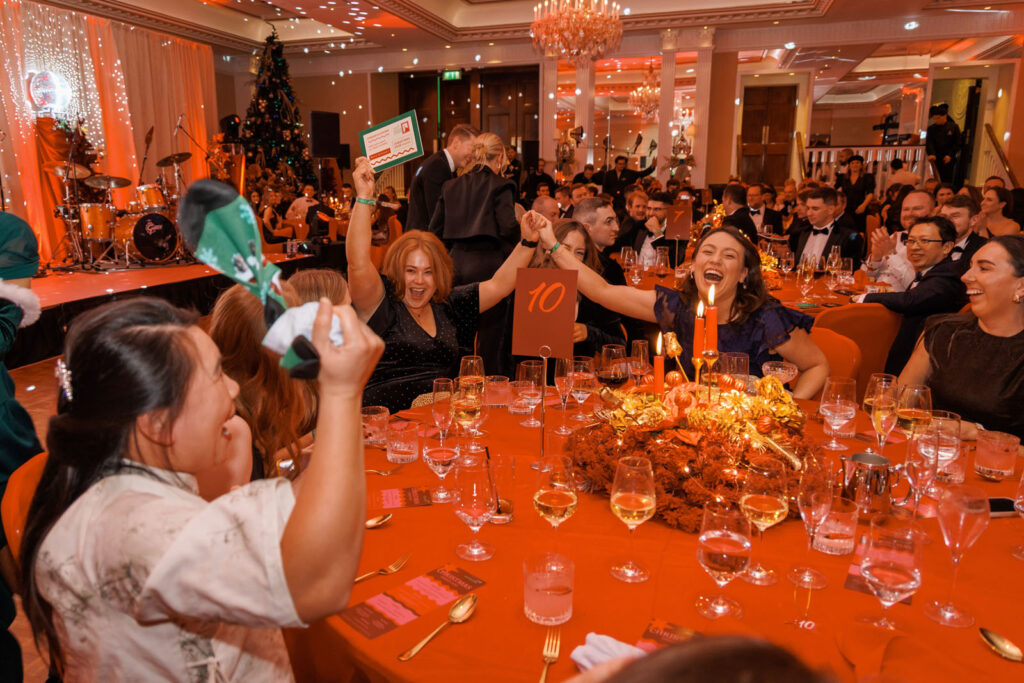 Joyful guests celebrating at a festive Christmas dinner party.