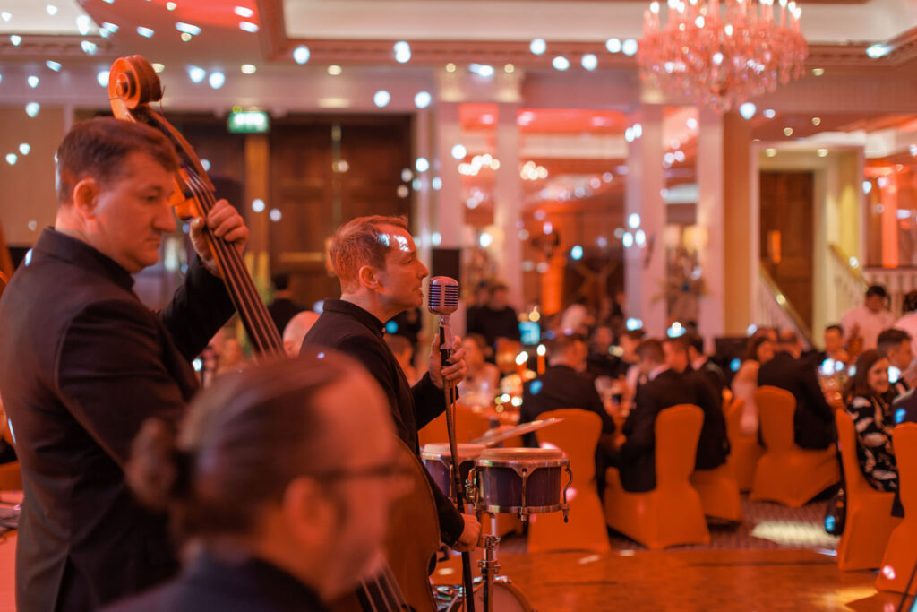 Live band entertains guests at a formal, warmly lit event.