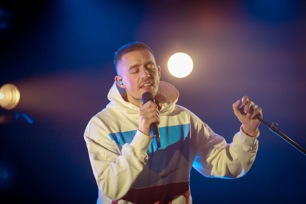 Male vocalist performing live on stage.