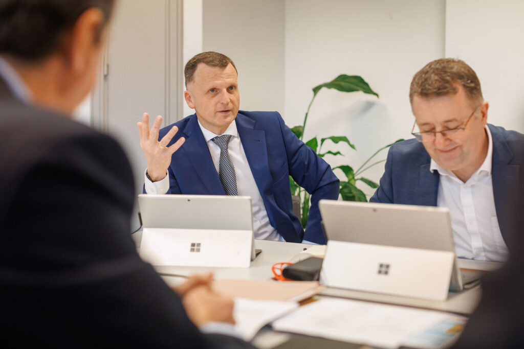 Man in blue suit speaking at a business meeting.