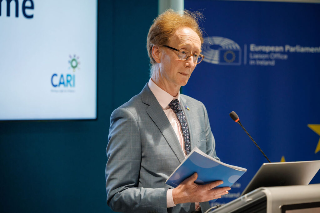 Man in suit speaking at European Parliament event.