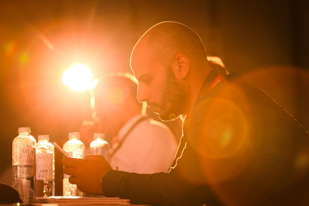 Man on phone, bathed in warm light.