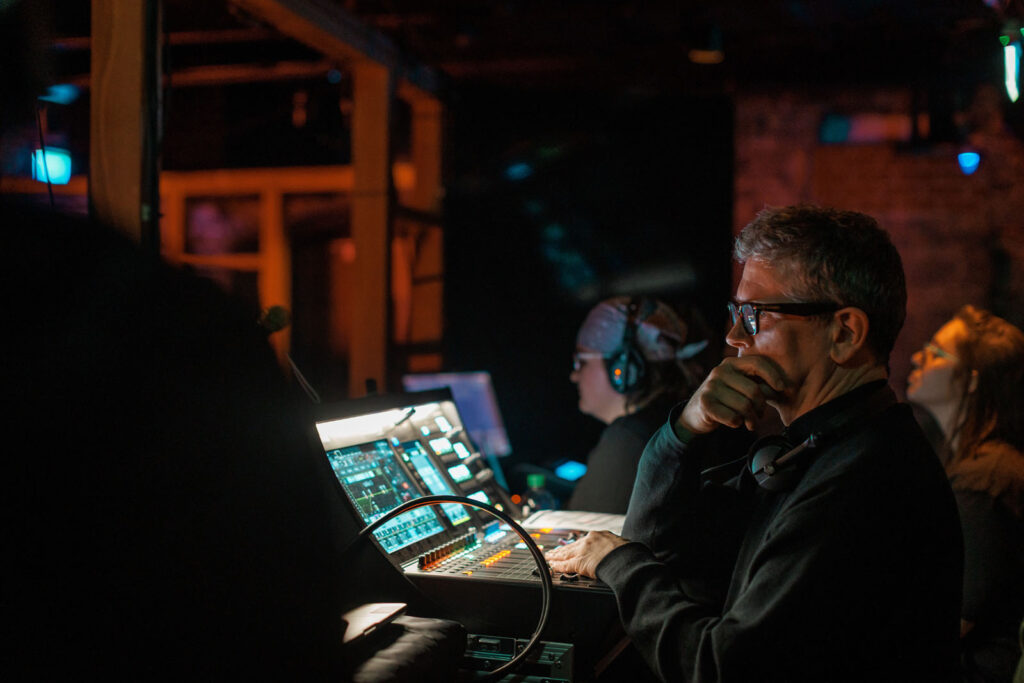 Man operating a soundboard at a live event.