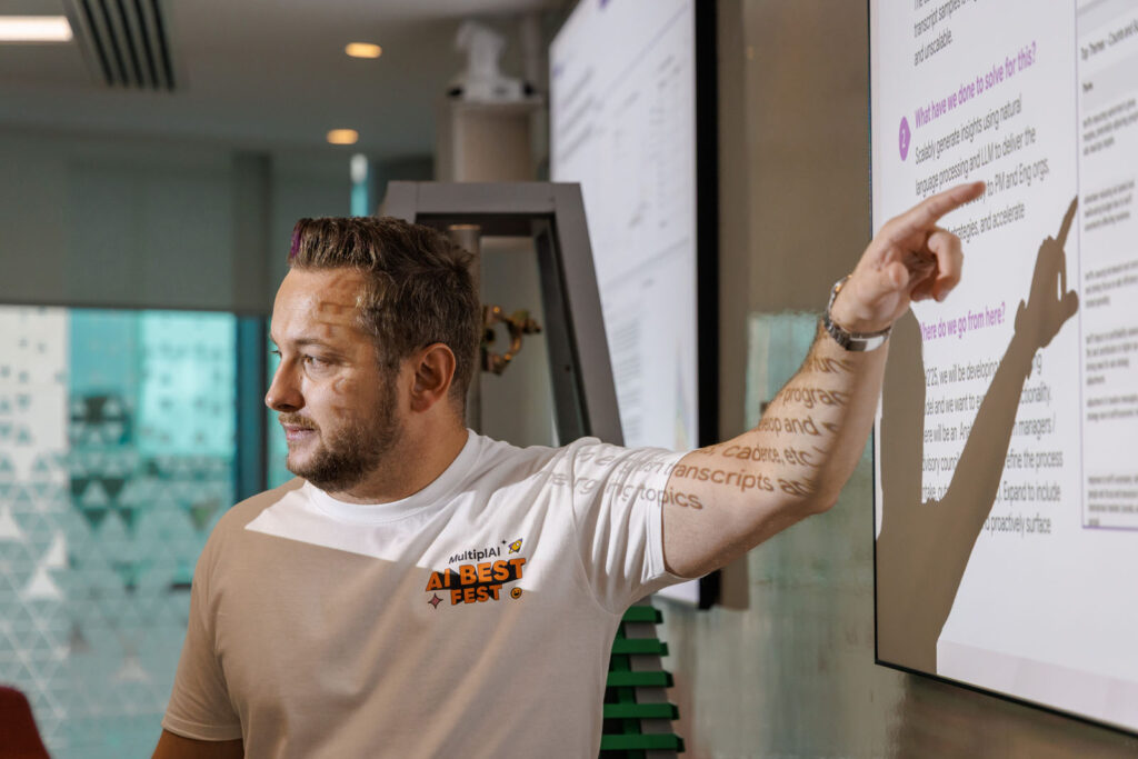Man presents AI concepts with projected text on screen and arm.