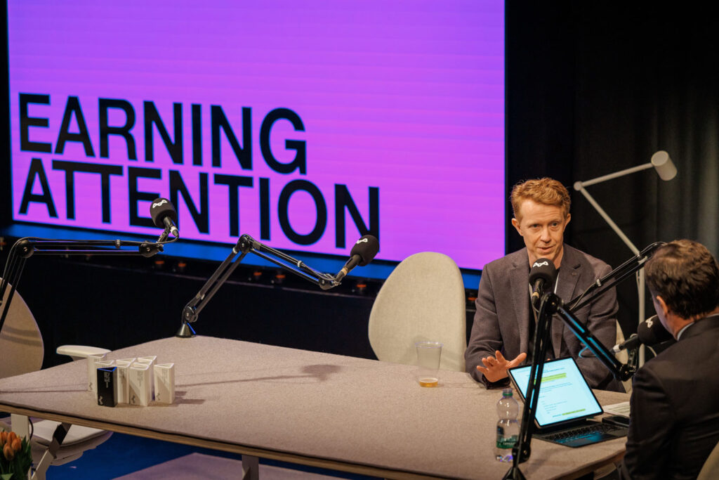 Men recording a podcast about earning attention.