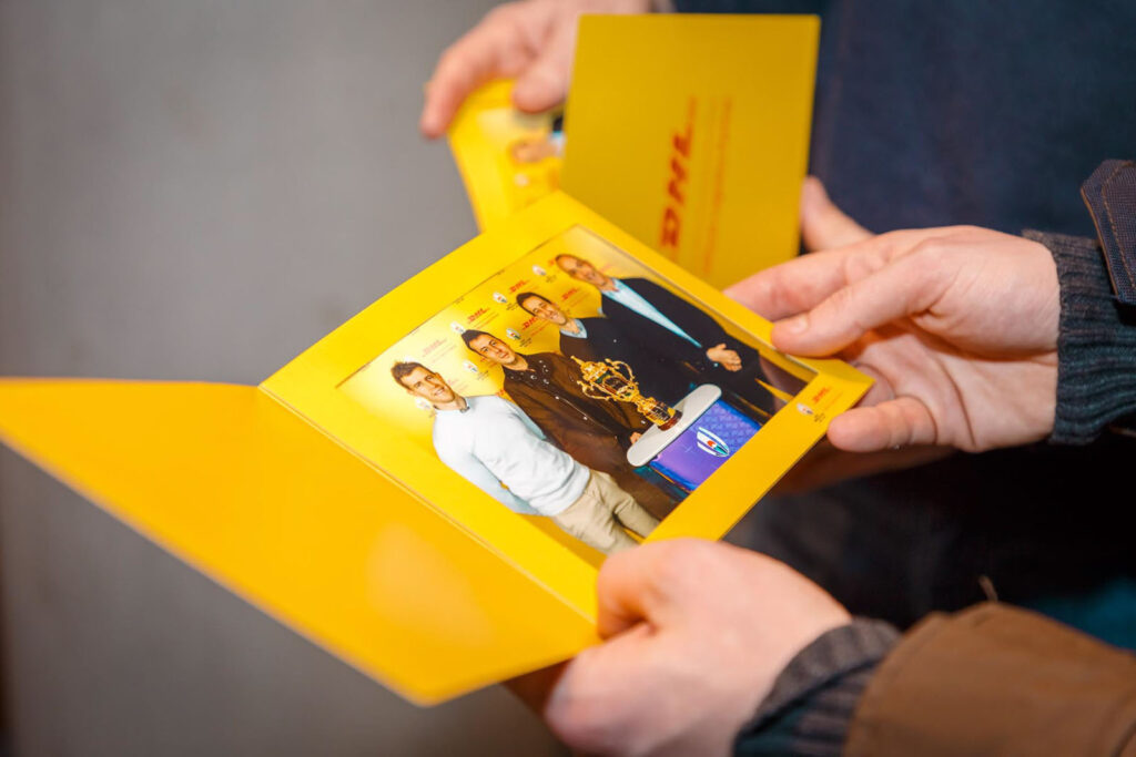 Men with trophy in DHL branded photo.