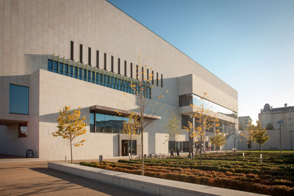 Modern building, autumn trees, and landscaped urban space.