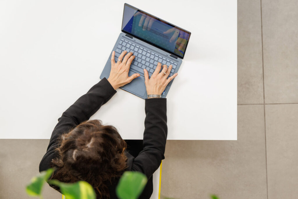 Overhead view of person typing on a laptop.