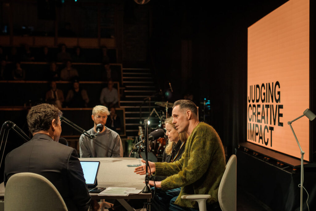 Panel discussion on "Judging Creative Impact" with an audience.