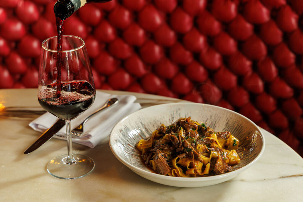 Pasta and red wine served in a restaurant.