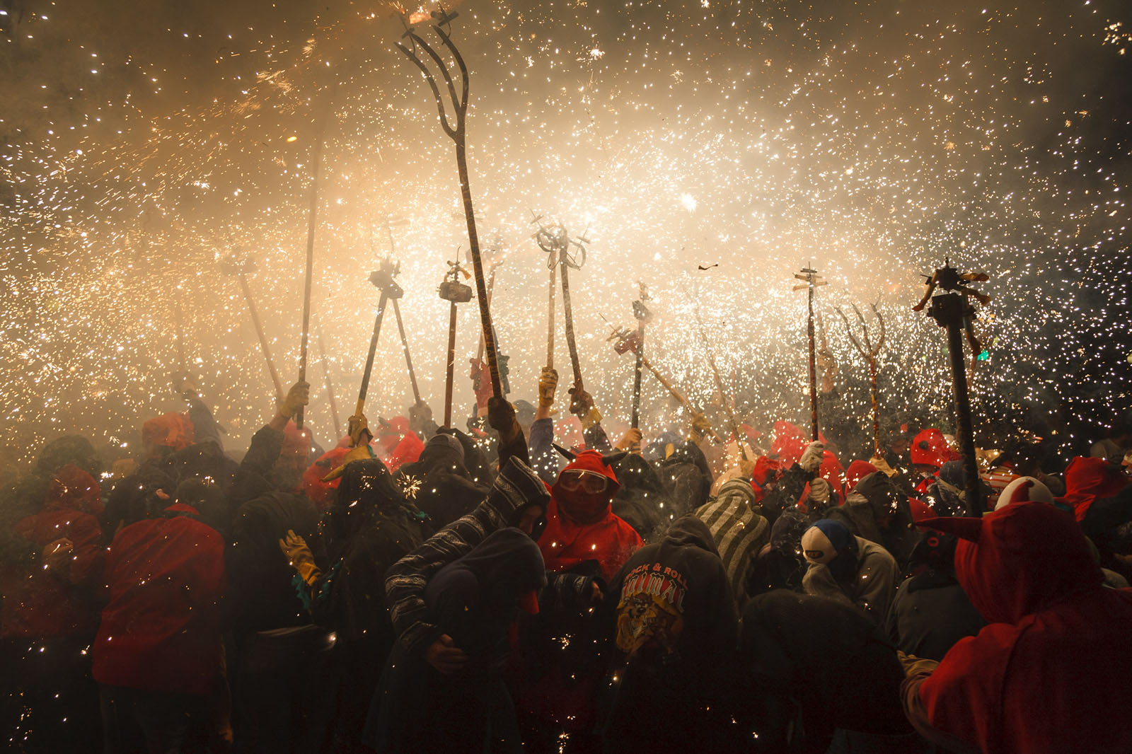 People celebrate with fireworks and sparklers at night.