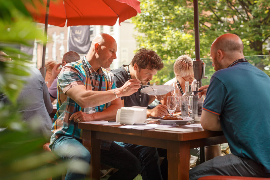 People dining outdoors at a sunny restaurant.