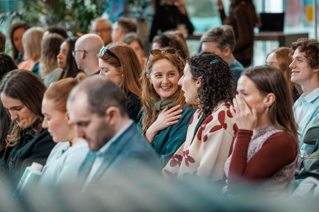 People smiling and interacting in an audience.