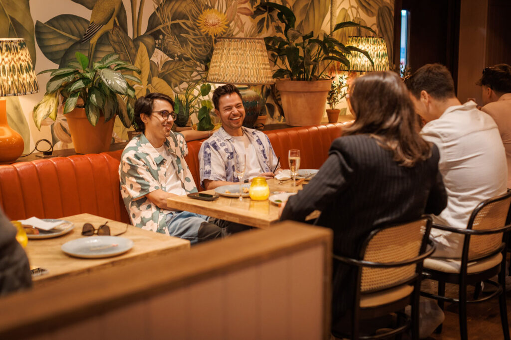 People socializing and laughing in a stylish restaurant.