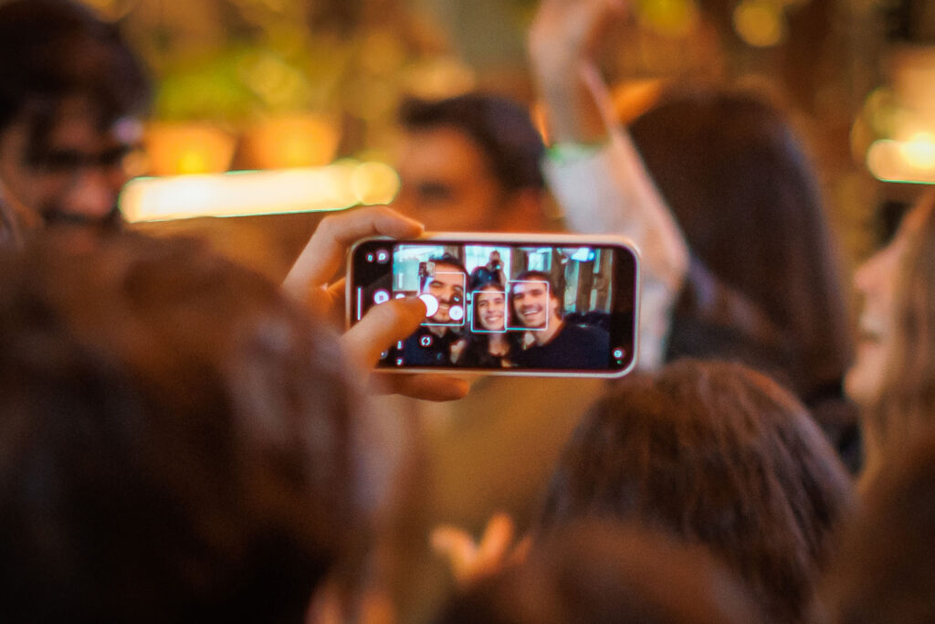 People taking a group selfie with a smartphone.