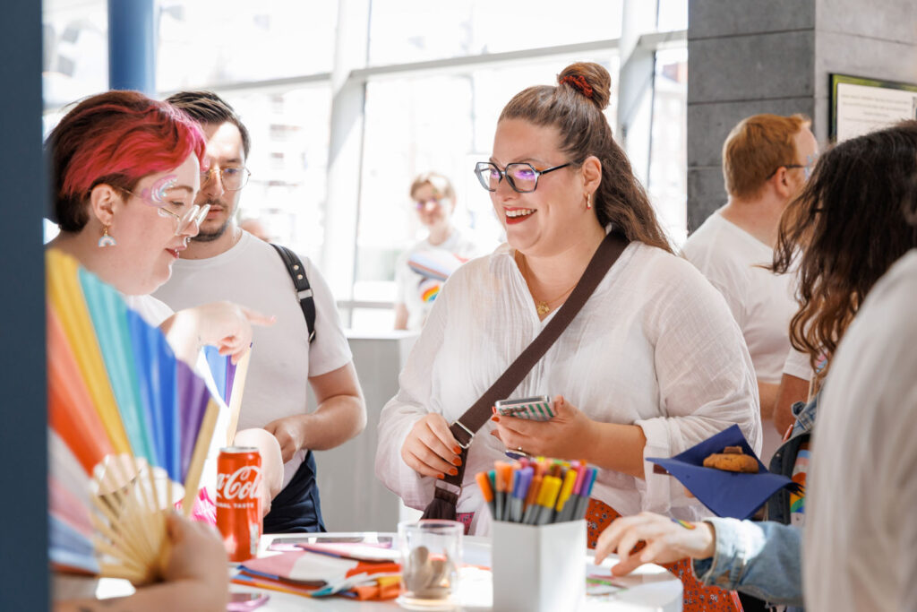 People with rainbow items enjoying a social event.